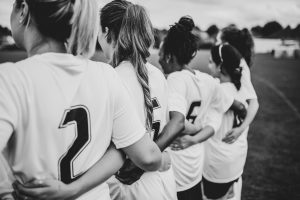 Female football players huddling together